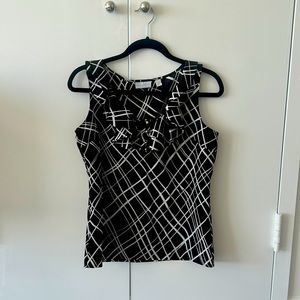 Black and white ruffled sleeveless blouse with 4 gold buttons